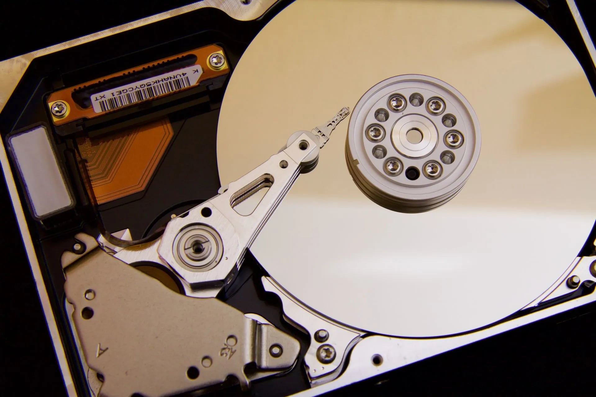 Macro close-up of a hard disk drive's actuator arm and platters
