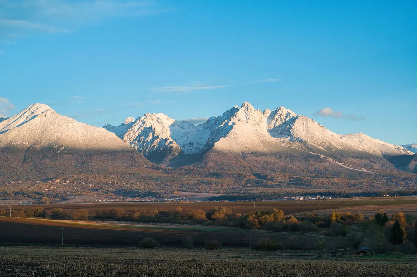 A snow-capped mountain landscape under a clear blue sky
